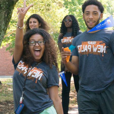Students cheering with New Paltz Swag